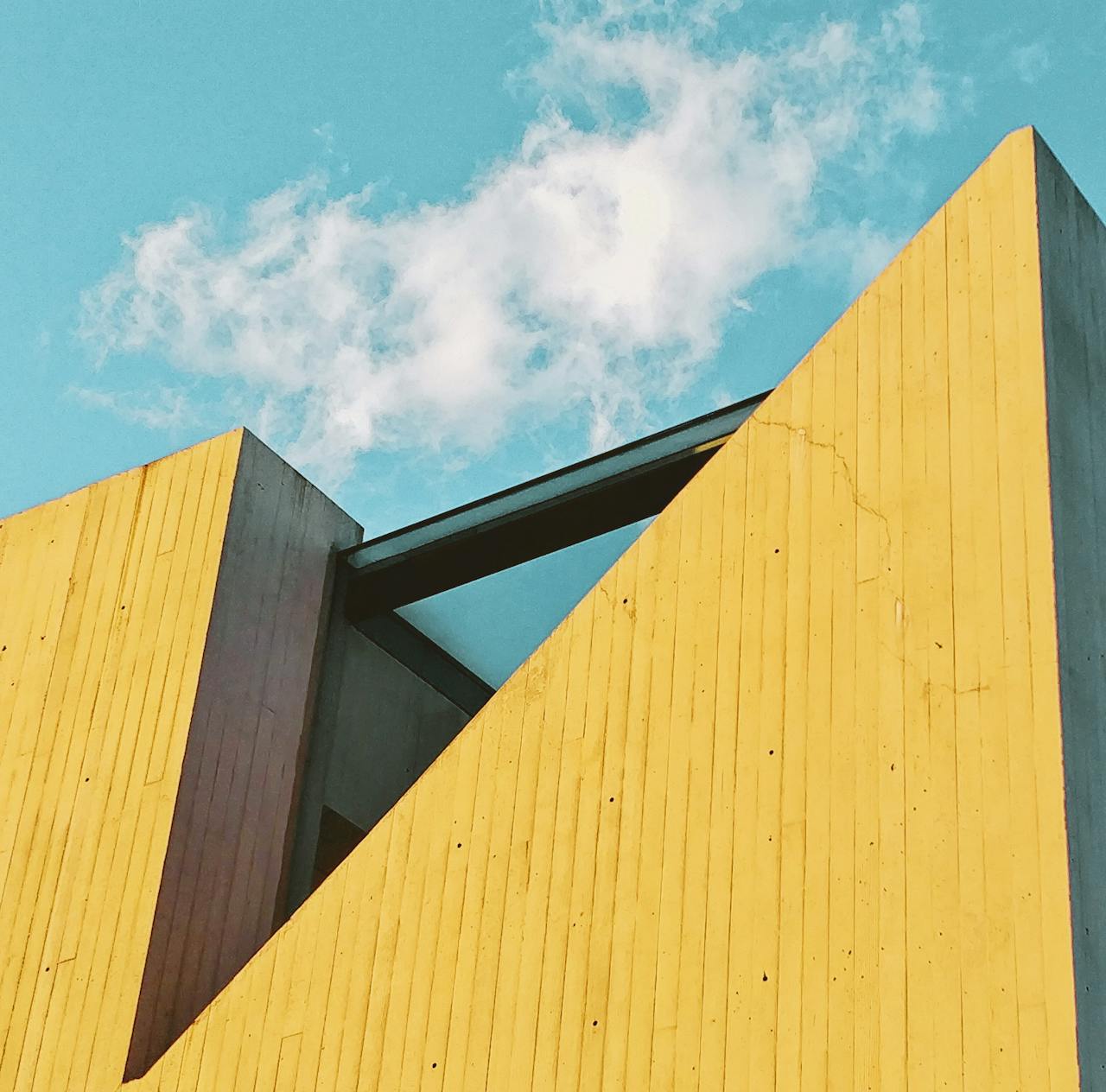 Contemporary architecture featuring bold yellow walls and clear blue sky.